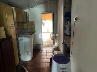 Interior de uma cozinha com piso de cerâmica e armários de madeira.