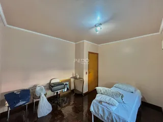 Quarto com piso de madeira e cama em uma residência em Lajeado.