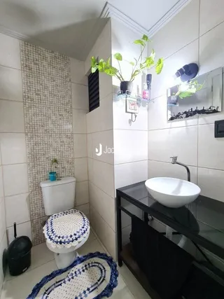 Foto de um banheiro interno com revestimento de cerâmica clara.