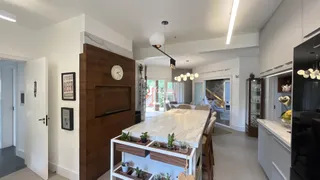 Ambiente moderno de sala de estar e cozinha com detalhes em madeira.