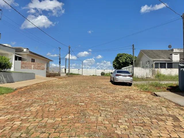 Vista externa de uma propriedade com área pavimentada de tijolos vermelhos.