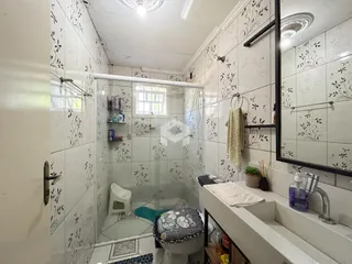 Foto de um banheiro com revestimento de azulejos brancos.