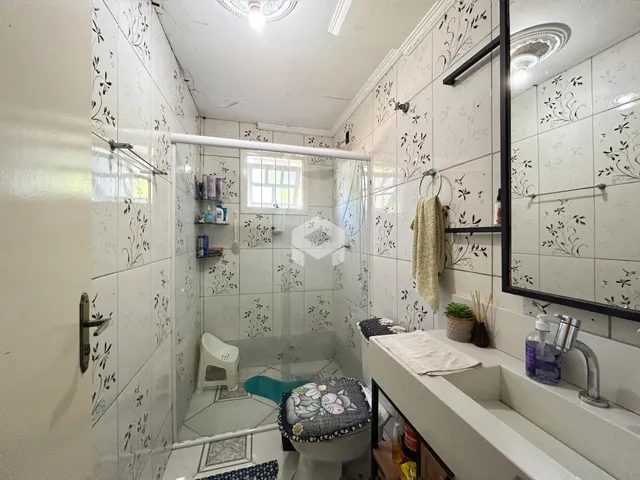 Foto de um banheiro com revestimento de azulejos brancos.