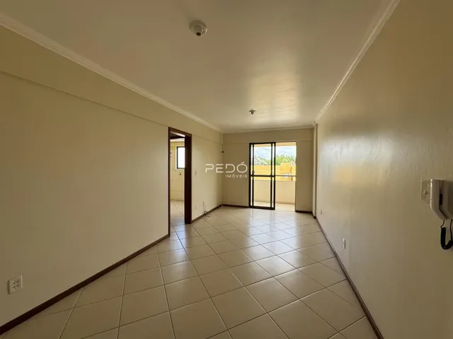 Hall de entrada com piso de cerâmica e paredes claras.