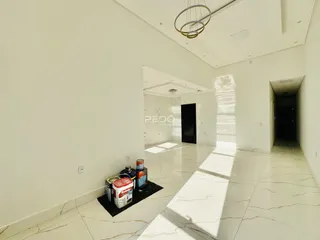 Hall de entrada com piso de mármore claro e paredes brancas em uma residência.