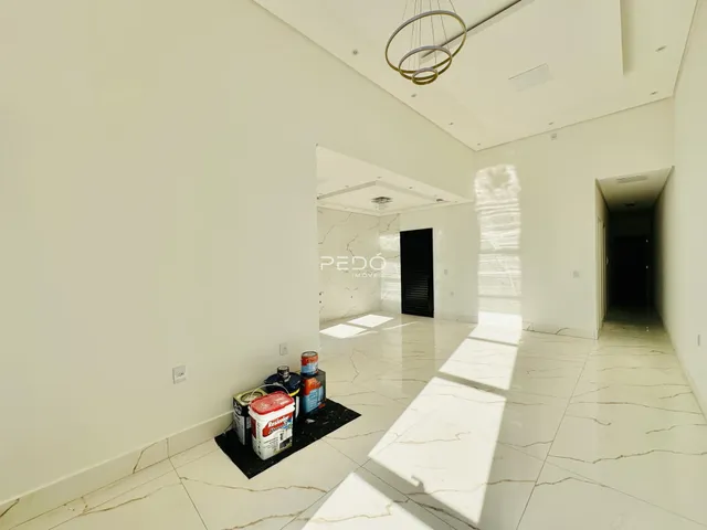 Hall de entrada com piso de mármore claro e paredes brancas em uma residência.