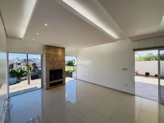 Sala de estar moderna com piso de porcelanato claro e lareira.
