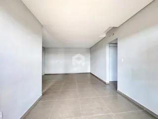 Ambiente interno de uma sala com piso de cerâmica e paredes brancas.
