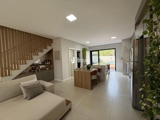 Sala de estar com piso de cerâmica e decoração de madeira clara.