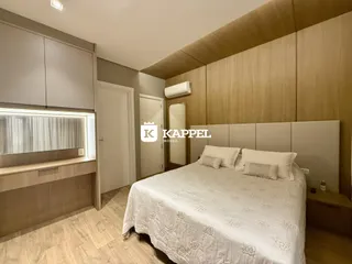 Um quarto com cama grande e armários em madeira clara.