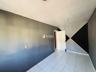 Vista de um corredor interno com paredes cinzas e piso de cerâmica.