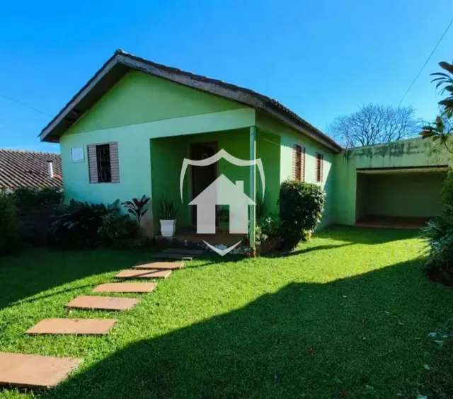 Fachada de uma casa verde em Lajeado, Brasil, com jardim gramado.