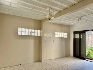 Interior de uma sala com paredes claras e piso de cerâmica.