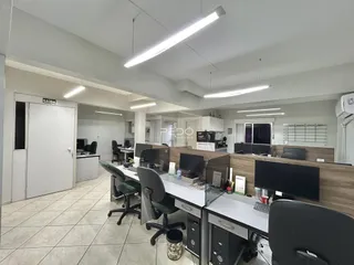 Ambiente de escritório moderno com mesas de trabalho e computadores em um imóvel no Brasil.