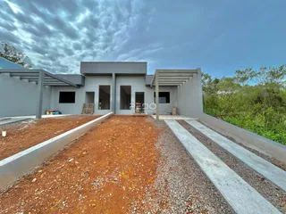 Fachada de uma casa em construção com área de terra no primeiro plano.
