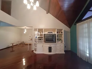 Sala de estar com piso de madeira e teto abobadado.