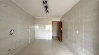 Corredor interno com paredes revestidas de azulejo claro.