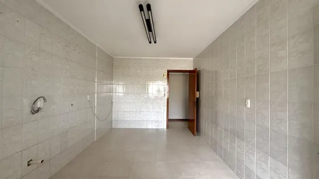 Corredor interno com paredes revestidas de azulejo claro.