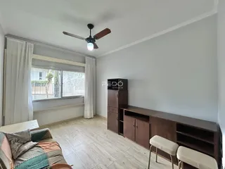 Sala de estar com piso de madeira clara e janela grande.