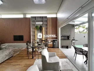 Sala de estar moderna com piso de madeira e vista para a área externa.