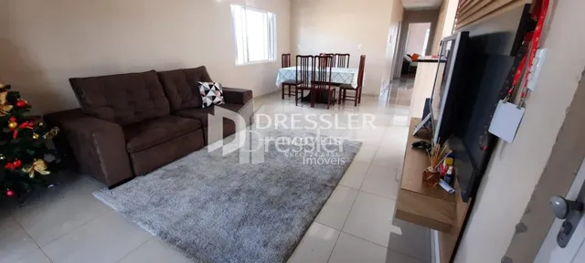Sala de estar com um sofá marrom e piso claro.