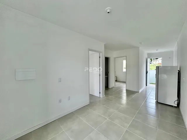 Hall de entrada com piso de cerâmica e paredes brancas em um imóvel no Brasil.