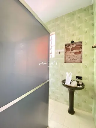 Corredor com paredes revestidas de azulejos verdes em uma propriedade.