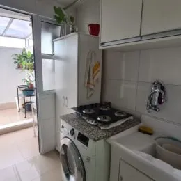 Cozinha com armários brancos e bancada.