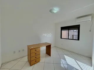 Foto de um cômodo interno com piso de cerâmica e uma mesa de trabalho.