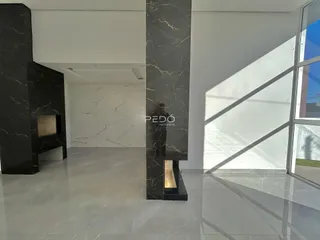 Hall de entrada com colunas de mármore escuro em um imóvel.
