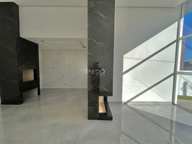 Hall de entrada com colunas de mármore escuro em um imóvel.