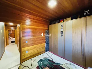 Quarto com parede de madeira e armários em um imóvel no Brasil.