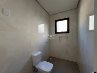 Foto de um banheiro com paredes em tom claro.