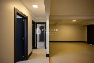 Hall de entrada com portas escuras em um imóvel.