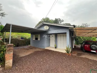 Fachada externa de uma residência em Lajeado, Brasil, com área de garagem e varanda.