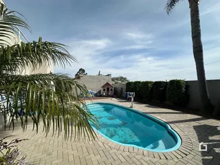Vista externa de uma piscina e jardim em uma propriedade no Brasil.