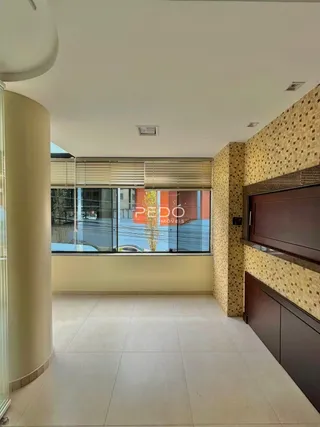 Interior de uma sala com piso de cerâmica e janela que dá para a água.
