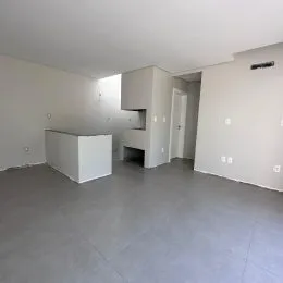 Foto de um ambiente interno com paredes brancas e piso cinza.