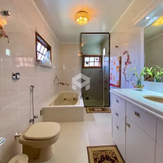 Foto de um banheiro com revestimento de cerâmica e banheira.