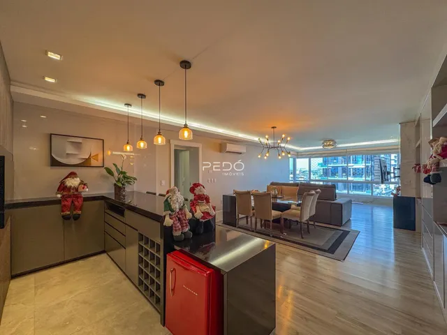 Interior de uma sala de estar moderna com cozinha aberta em Lajeado.