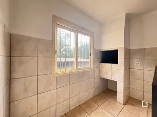 Vista interna de um ambiente com paredes revestidas de azulejos e uma janela.