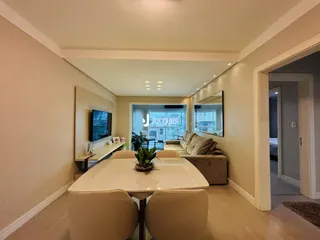Sala de estar com mesa de jantar e sofá em um apartamento.