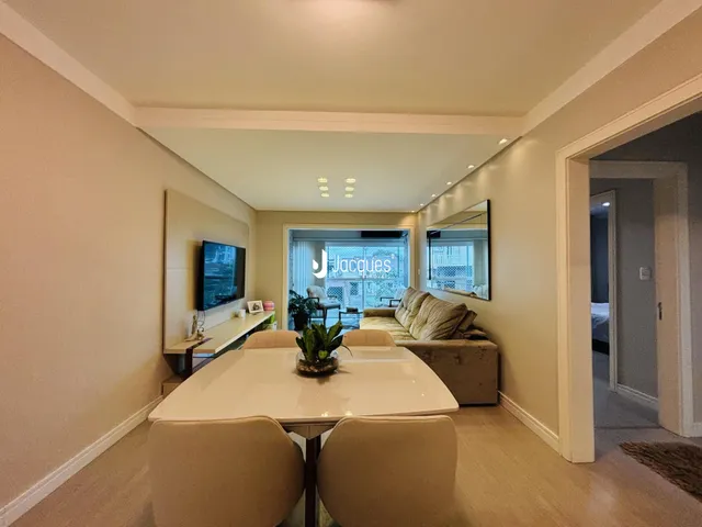 Sala de estar com mesa de jantar e sofá em um apartamento.