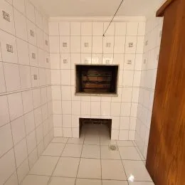 Uma parede interna com revestimento de azulejos brancos.