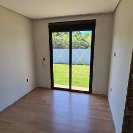 Sala de estar com porta de vidro que dá acesso a um gramado verde.