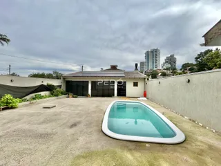 Vista externa do imóvel mostrando a piscina e o quintal.