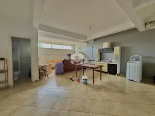 Ambiente interno de uma sala de estar com piso de cerâmica e cozinha em Lajeado.