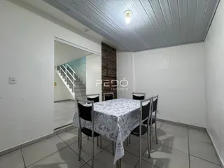 Ambiente interno de uma sala com mesa posta e escadaria.