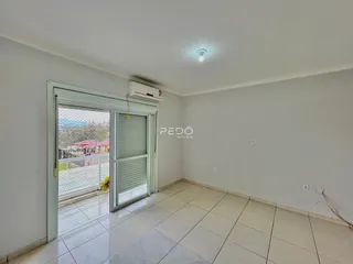 Interior de uma sala com piso de cerâmica e portas de vidro.