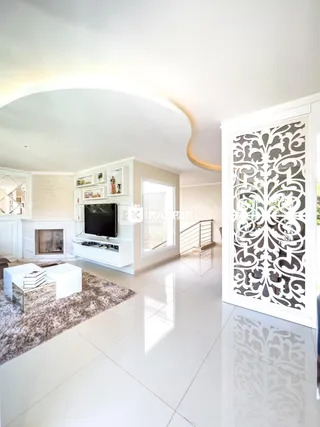 Sala de estar moderna com lareira e televisão em um ambiente claro.